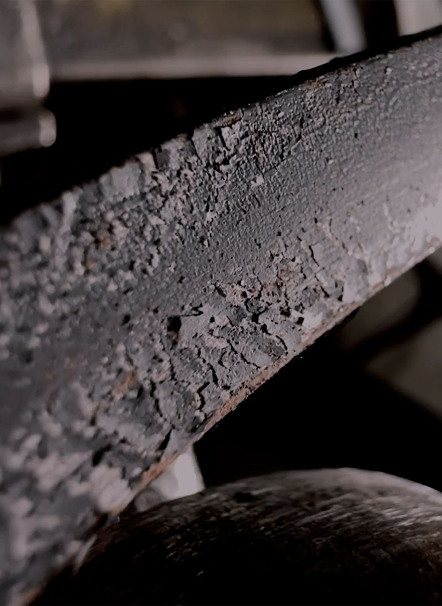 Carbon flaking off an iron bar while bending